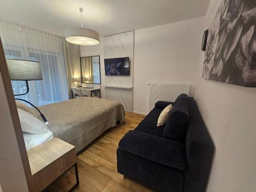 a living room with a couch and a bed at City Sense - Brand New Apartment Close to the City Center and Main Station in Wrocław