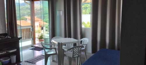 um quarto com uma mesa e cadeiras e uma janela em Chalé Boa Vista em Ilhabela