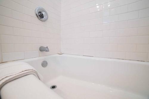 a white bathroom with a tub and a toilet at Sea View, Flower Garden, A/c, W/d, Renovated in Hermosa Beach
