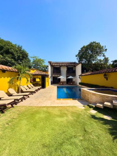 a backyard with a swimming pool and a house at Nueva Granada Hotel Colonial -Centro Histórico- in Santa Fe de Antioquia