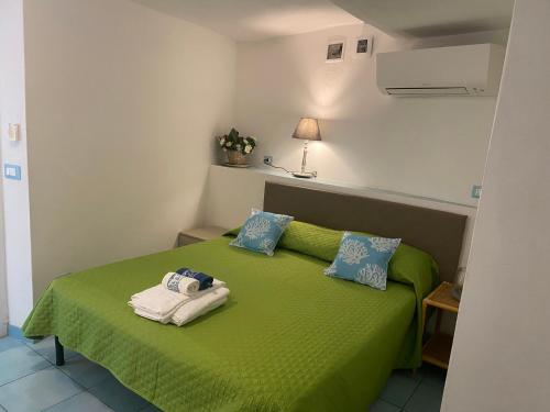 a room with a green bed with towels on it at Ponzamania IL Pescatore in Ponza