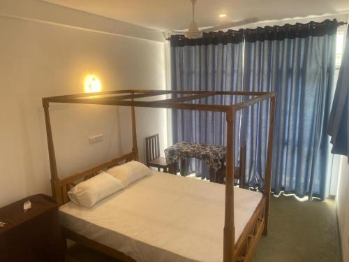 1 dormitorio con cama con dosel y ventana en Charle's House Ahangama, en Ahangama