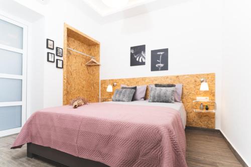 1 dormitorio con 1 cama grande con manta rosa en Kanevaro 2 Chania Old Town, en La Canea