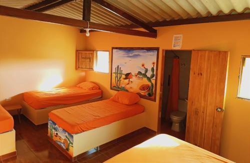 - une chambre avec 2 lits et un tableau mural dans l'établissement EL KACHI Hospedaje y Restaurante, à Uribia