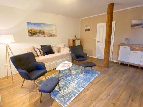 ein Wohnzimmer mit einem Sofa und 2 Stühlen in der Unterkunft datKrughuus in Emden
