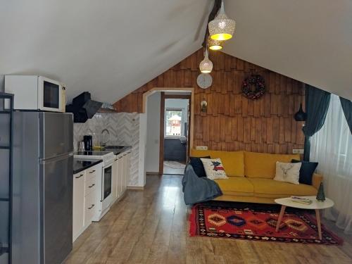 gonta cottage في سلافسكي: غرفة معيشة مع أريكة صفراء في مطبخ