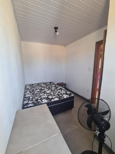 a small room with a bed and a camera in it at Recanto das Pedras- Casa Pedra Ardósia - Com vista para o mar in Jaguaruna