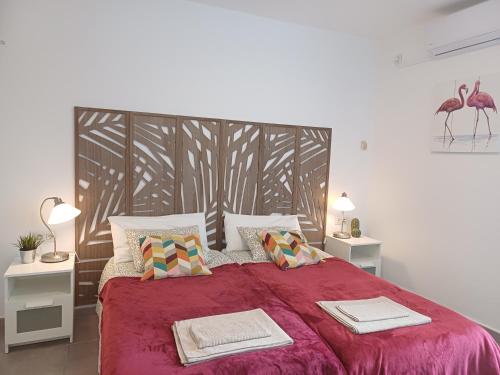 a bedroom with a red bed with two towels on it at Happy Heart Los Molinos in Costa Teguise