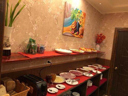 Hotel Vista Mar في بويرتو مونت: منضدة حمراء عليها صحون وصحون