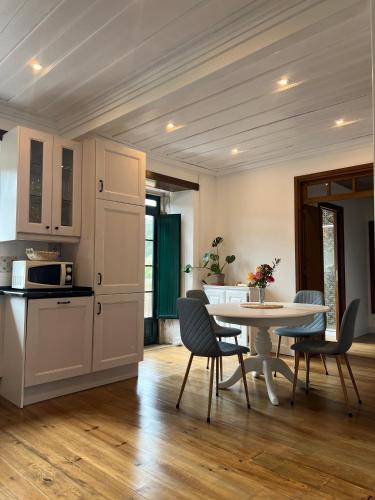a kitchen and dining room with a table and chairs at Quinta das Amoras - Au coeur des oliviers in Podentes