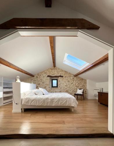 a bedroom with a bed and a stone wall at Quinta das Amoras - Au coeur des oliviers in Podentes