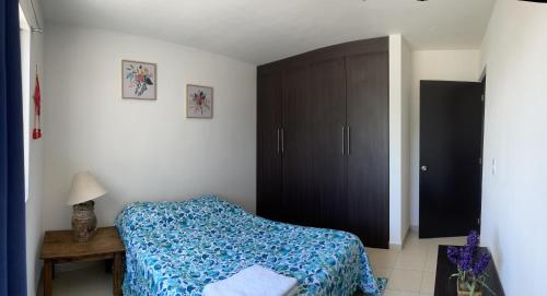 a bedroom with a bed and a black cabinet at Departamento amueblado in San Luis Potosí