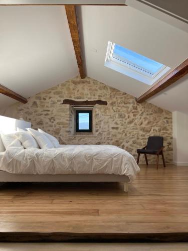 a bedroom with a large bed and a window at Quinta das Amoras - Au coeur des oliviers in Podentes