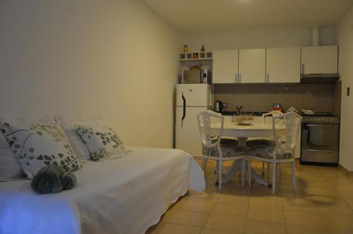 a bedroom with a bed and a table and a kitchen at Espacio Aristobulo in Comodoro Rivadavia