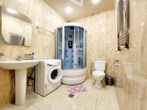ein Badezimmer mit einer Waschmaschine neben einem WC in der Unterkunft King in Zaghkadsor
