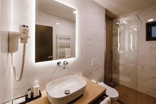 a white bathroom with a sink and a shower at Pensiunea Sylvania in Sovata