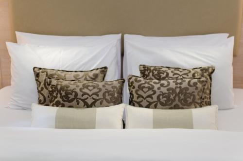 
two white beds with pillows and pillows on them at Toledo Amman Hotel in Amman
