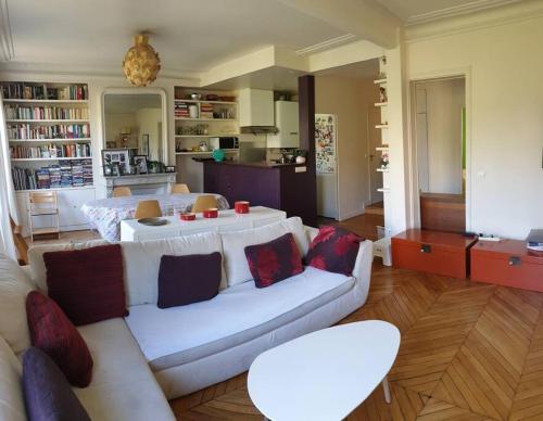 un salon avec un canapé blanc et une table dans l'établissement Cosy apartment in Paris center, à Paris