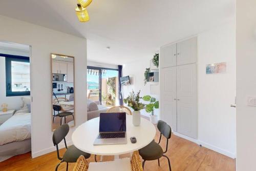 Cette chambre blanche dispose d'une table et d'un ordinateur portable. dans l'établissement Terrasse avec aperçu mer, Piscine, Plage à 200m, à Cannes