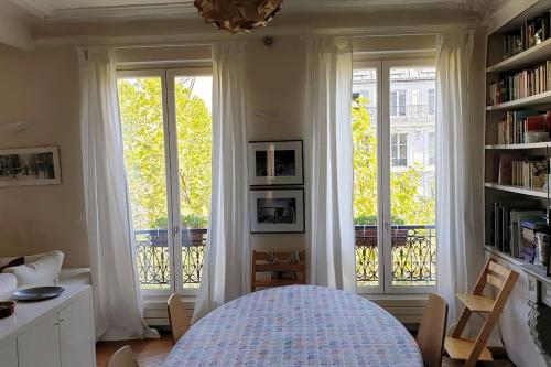 - une chambre avec de grandes fenêtres et un lit dans un dortoir dans l'établissement Cosy apartment in Paris center, à Paris