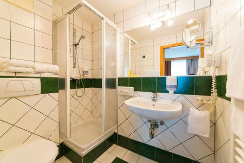 a bathroom with a sink and a shower at Der Thaller - Wirtshaus - Restaurant - Hotel in Anger