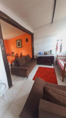 uma sala de estar com um sofá e um tapete vermelho em Suites Vila Verde em Búzios RJ. em Búzios