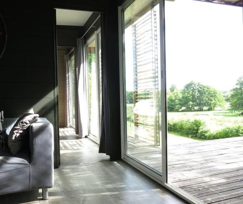 d'un salon avec une grande porte coulissante en verre. dans l'établissement Lodge Ultranature, Envrionnement naturel - 25 mn du Puy - Terrasse avec Vue Imprenable - Idéal Déconnexion, à Saint-Mesmin