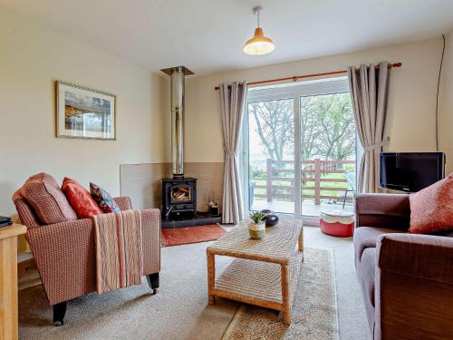 ein Wohnzimmer mit zwei Stühlen und einem Kamin in der Unterkunft 1 Bed in Beauly 82778 in Beauly