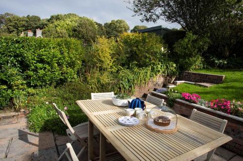 a wooden table and chairs in a garden at Uwch-Y-Mor in Llanfairfechan