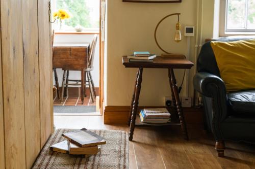 a living room with a table and a chair and a desk at Uwch-Y-Mor in Llanfairfechan