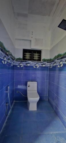 Habitación con suelo de baldosa azul y baño con aseo. en LemonTree Homestay & Camping en Kollam