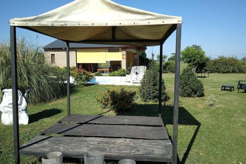 a gazebo with a wooden table in a yard at Casa de Descanso. in Villa María