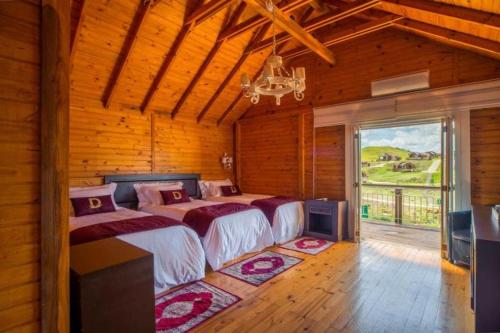 a bedroom with two beds and a large window at Bourbon Serra Gaúcha Divisa Resort in São Francisco de Paula