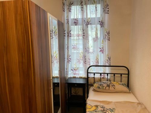 a small bedroom with a bed and a window at Eilenburg Apartments Nordsachsen in Eilenburg