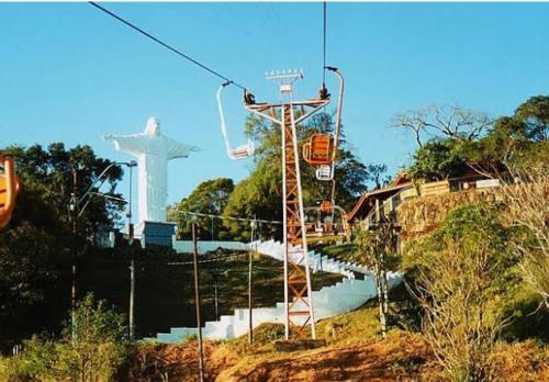 a gondola ride on a river with a cross in the background at Apartamento Bem Localizado in Serra Negra