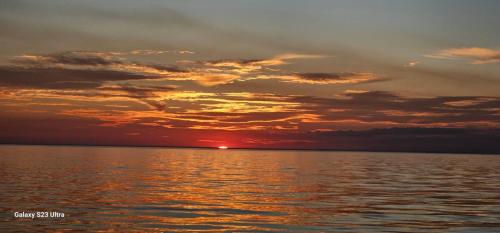 una puesta de sol sobre un cuerpo de agua en Departamento de Playa San Bartolo Ocean Reef - SOL, ARENA Y MAR, en San Bartolo