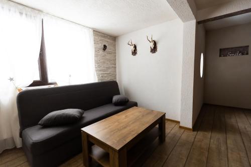 a living room with a couch and a wooden table at Casa Danielle in Topliţa