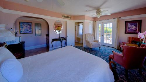 a bedroom with a white bed and a living room at Shorelight Inn in Benicia