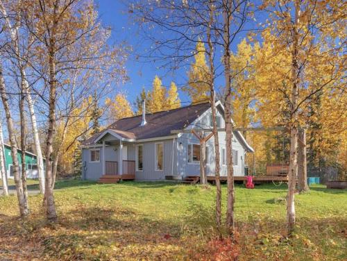 una pequeña casa blanca en medio de los árboles en Cozy Cottage w/Pioneer Peak View, en Palmer
