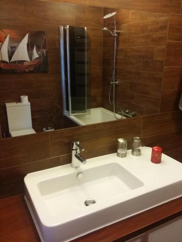 a bathroom with a white sink and a mirror at Apartament Słupsk in Słupsk