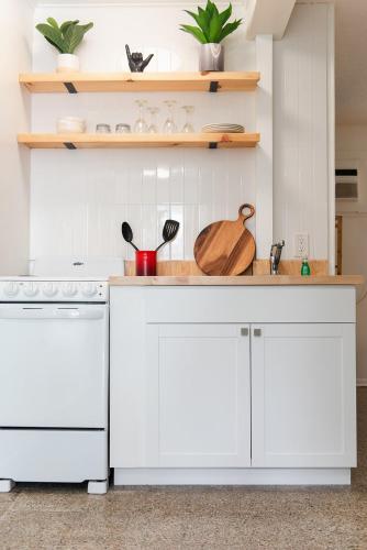 a kitchen with white cabinets and a white dishwasher at Seaspray Surf Lodge in Vero Beach