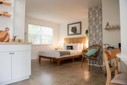 a bedroom with a bed and a table and a chair at Seaspray Surf Lodge in Vero Beach