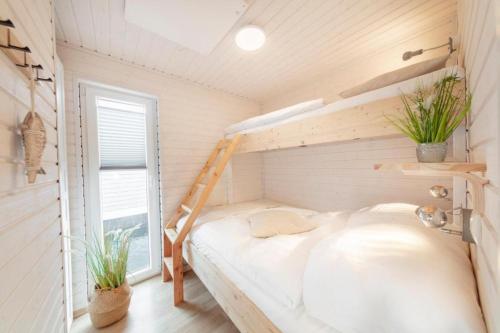 Hausboot Rán mit Dachterrasse in Kragenæs auf Lolland/DK في Torrig: غرفة نوم مع سرير بطابقين وسلم