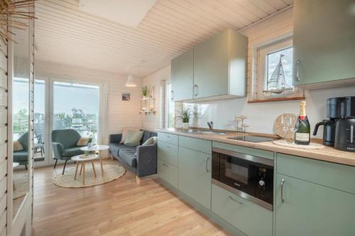 uma cozinha com um lavatório e uma sala de estar em Hausboot Rán mit Dachterrasse in Kragenæs auf Lolland/DK em Torrig