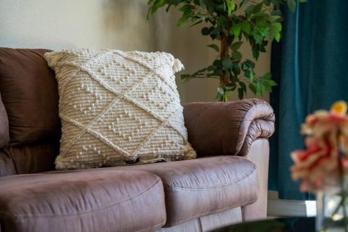 a brown couch with a pillow on top of it at Magical Oasis Retreat in Orlando