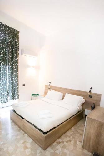 a bedroom with a large bed with white sheets at Hall inn B&B in Chiostro in Naples