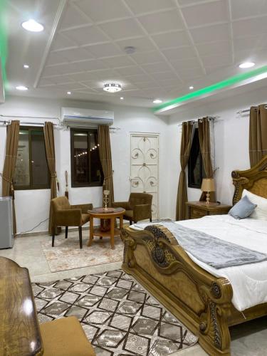 a bedroom with a bed and a couch and chairs at الريان للنزل الخضراء 
