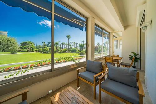 une chambre avec deux chaises et une grande fenêtre dans l'établissement Wdf 3 bedrooms apartment on the Croisette !, à Cannes
