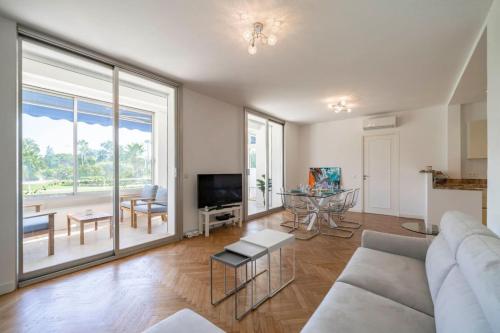 un salon avec un canapé et une grande fenêtre dans l'établissement Wdf 3 bedrooms apartment on the Croisette !, à Cannes