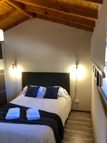 a bedroom with a large bed with two towels on it at Del Paralelo 2 in El Bolsón